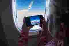 Child on airplane taking photos