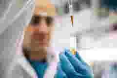 Scientist using pipette to dispense liquids