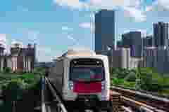 Train passing in front of a city skyline with skyscrapers