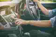 Driver pressing the turn-on audio button of the loudspeaker of the car