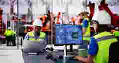 Engineers Using Computers In Industrial Factory