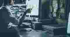 young man working on the computer touching the screen with graphics of the ReliaSoft BlockSim platform for system reliability