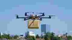 Drone delivering a big brown post package into the city