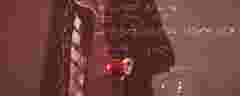 Male figure dressed like Newton holding a red apple in the hand
