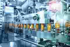 Beverage factory, Conveyor belt with juice in bottles, Industrial Interior in blue color, food and drink production line process.