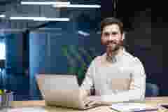 Expert Engineer sits at a desk with a laptop