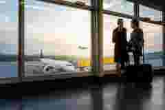Two business travelers standing at airport window