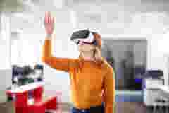 Curious businesswoman using VR goggles