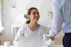 Head shot young happy mixed race female employee taking envelope with money reward from male boss team leader. Smiling biracial manager satisfied with cash bonus for great work performance at office.; Shutterstock ID 1537134923