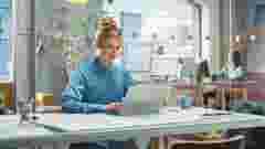 Portrait of beautiful caucasian woman working on laptop computer at a bright creative office