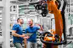 two colleagues working with a robotic arm