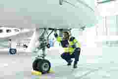 Ground personnel at the airport check the hydraulic system of the landing gear of the aircraft 