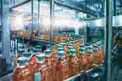 Conveyor belt juice in bottles beverage factory interior in blue color industrial production line