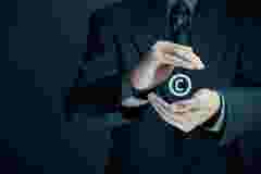 man in a suit and tie with his hands in a circle around the C symbol from the copyright