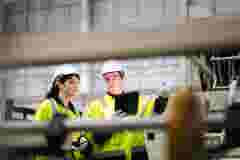 Maintenance engineer inspects machinery in a cardboard parts factory
