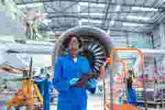 Portrait of female aircraft maintenance engineer in aircraft hangar
