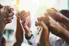 Group of businesspeople holding hands together