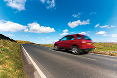 A car speeds by on a country road.