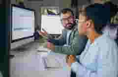 Software engineers analyzing data on computer screens