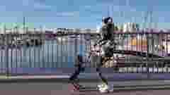 THEMIS large and BRUCE small Humanoid Robots by Westwood Robotics walking by waterfront