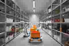 Storage room of a restaurant with robot arms preparing food