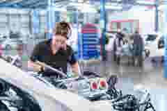 Female engineer assembling car in racing car factory